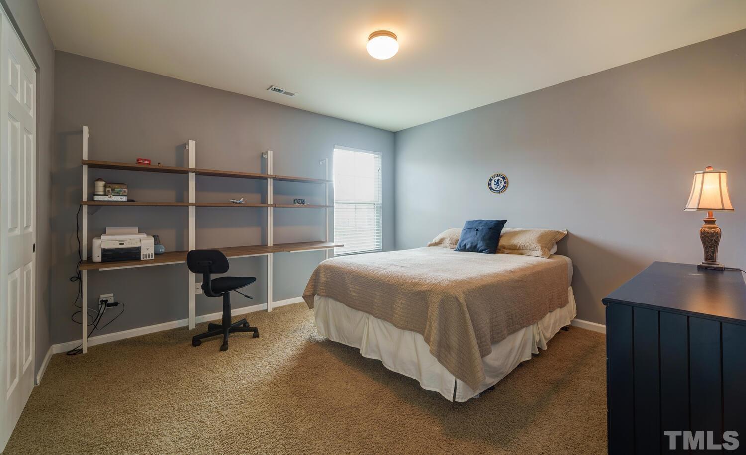 4104 Burnaby Street Raleigh, NC 27616 - Photo 26 of 59 a bedroom with a bed and a lamp on desk