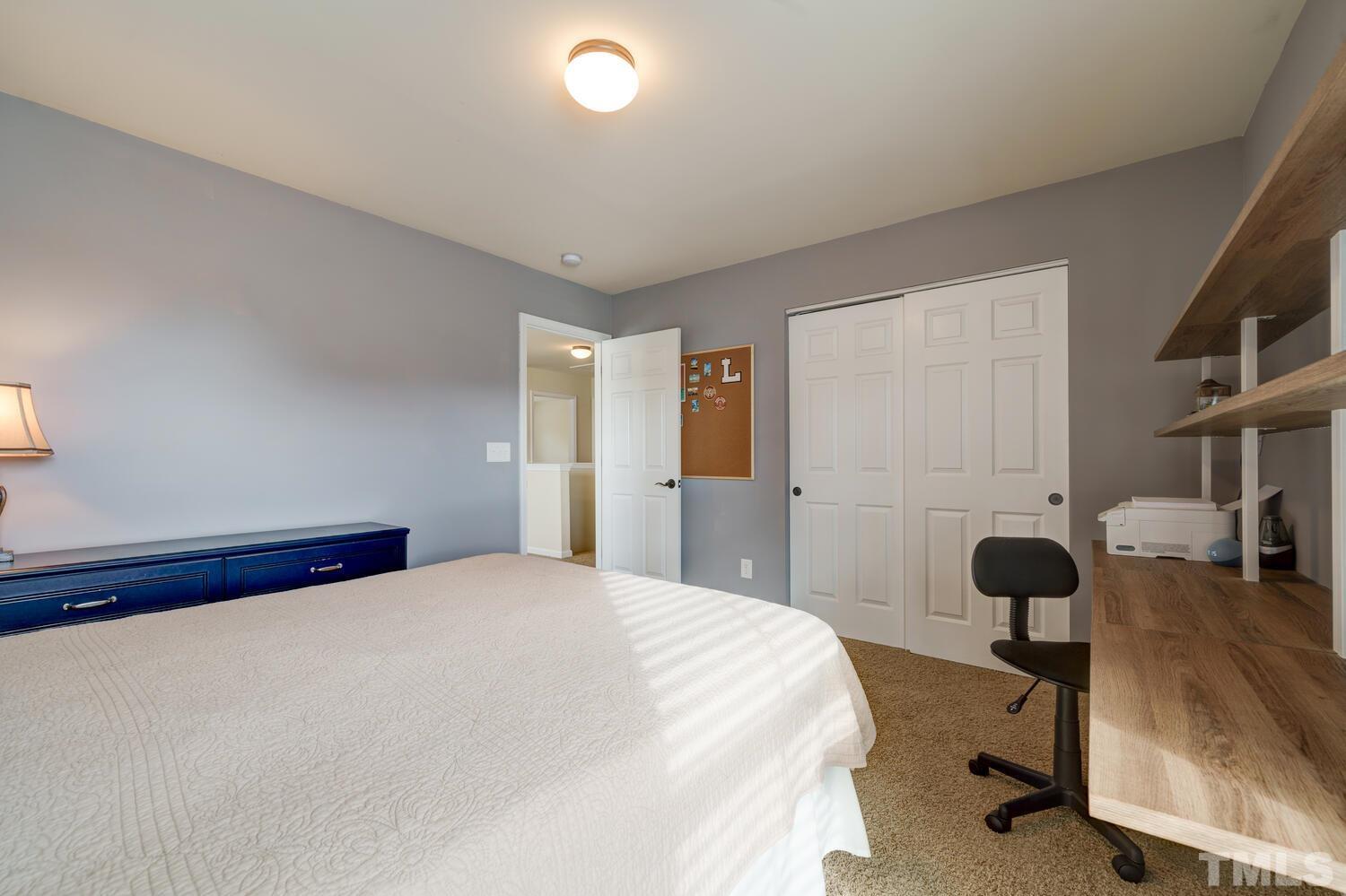 4104 Burnaby Street Raleigh, NC 27616 - Photo 28 of 59 a bedroom with a bed and a large mirror next to a window