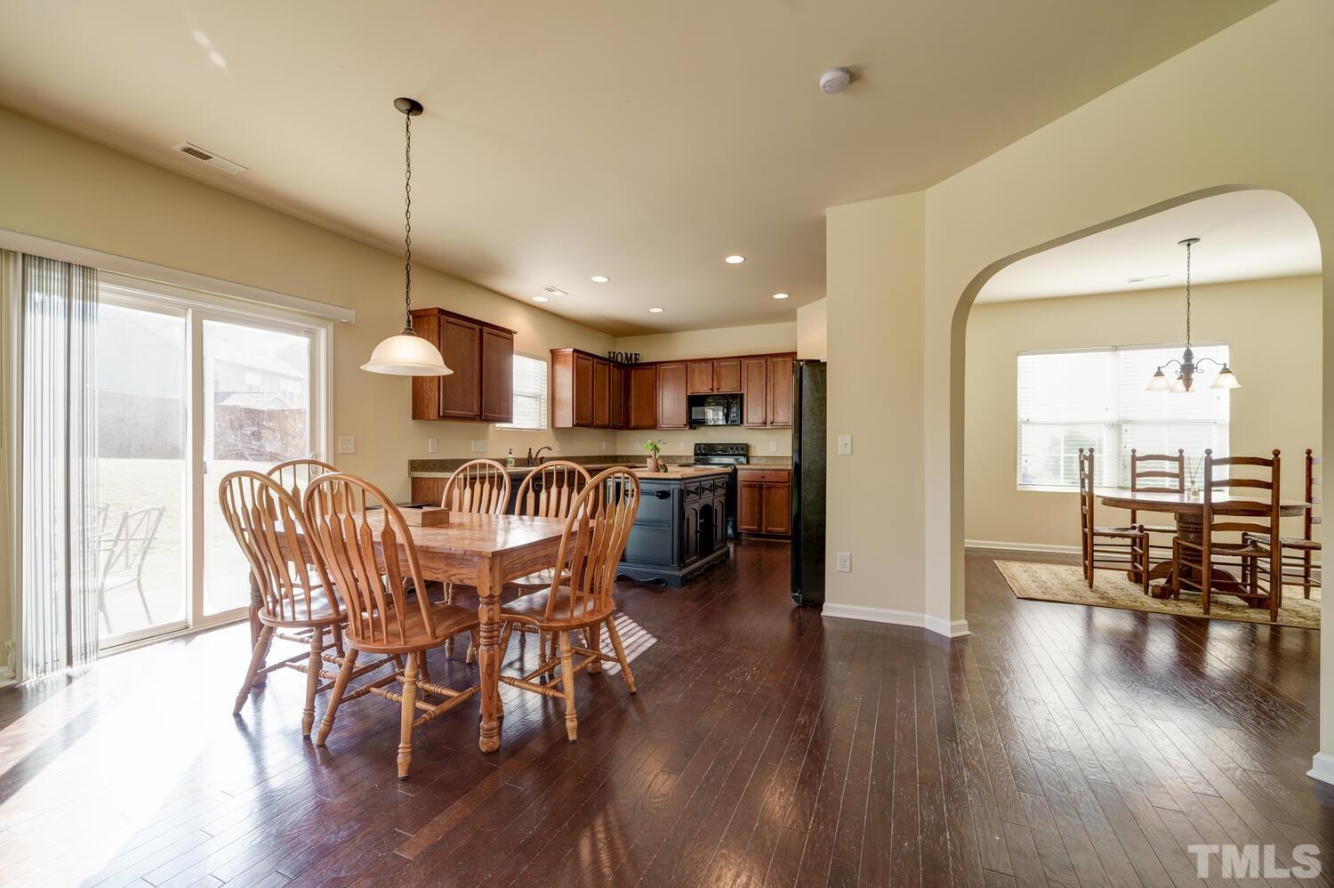4104 Burnaby Street Raleigh, NC 27616 - Photo 9 of 59 a view of a dining room and livingroom with furniture wooden floor a chandelier