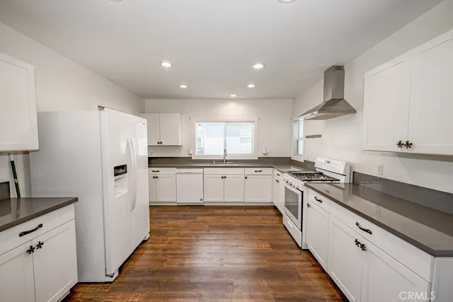 a large kitchen with cabinets stainless steel appliances a sink and a counter top space