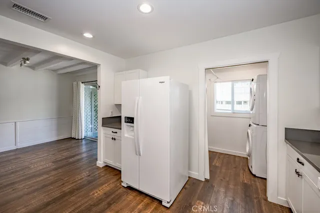 a view of a kitchen with wooden floor and electronic appliances
