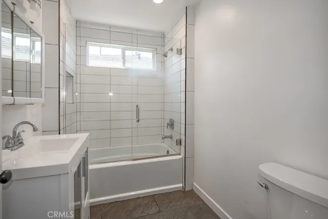 a bathroom with a bathtub shower sink vanity and toilet