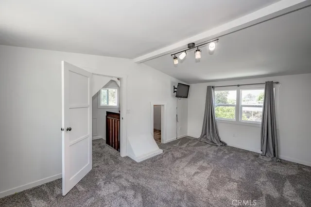 a view of an empty room with window and stairs