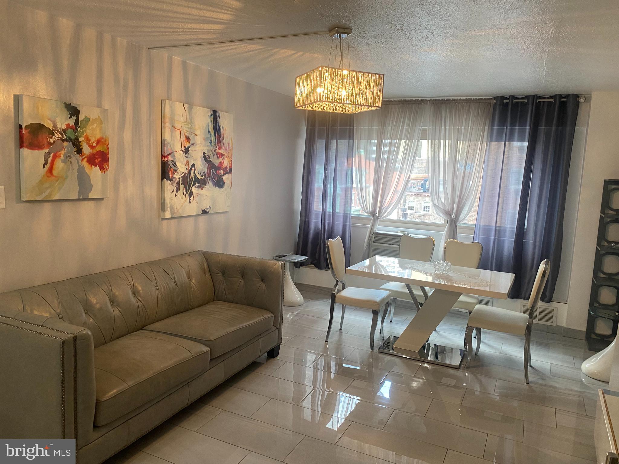 2101 Chestnut Street, Unit 519 Philadelphia, PA 19103 - Photo 11 of 21 a living room with furniture and a chandelier