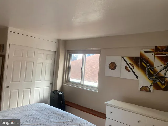 a room with a bed and a refrigerator