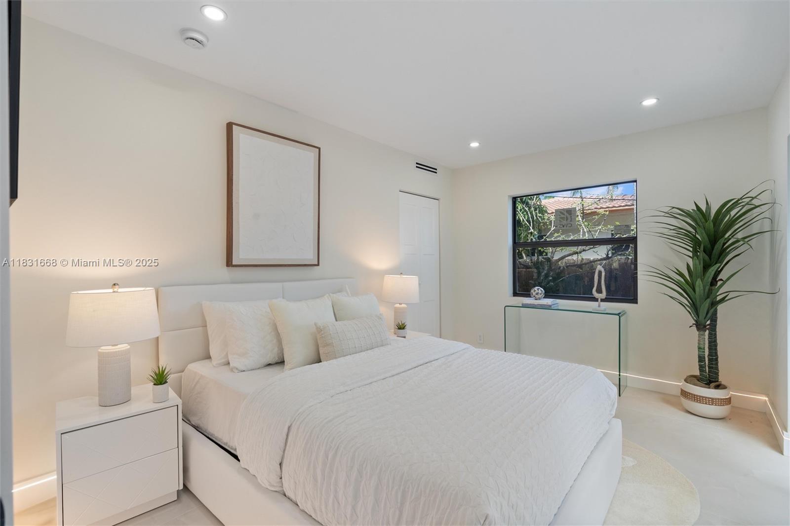 1108 Harrison Street Hollywood, FL 33019 - Photo 17 of 19 a bedroom with a large bed and a potted plant