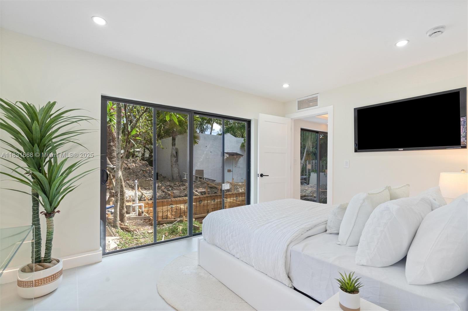 1108 Harrison Street Hollywood, FL 33019 - Photo 19 of 19 a bedroom with a large bed and a flat screen tv