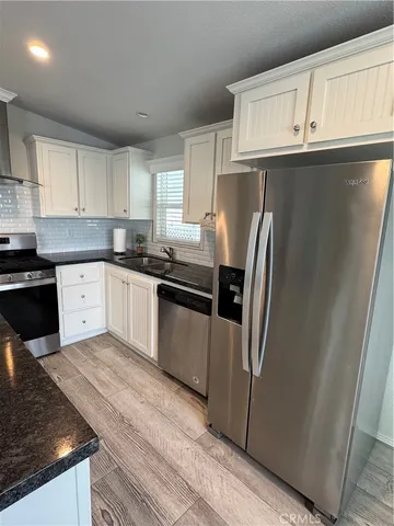 a kitchen with granite countertop a refrigerator and a sink