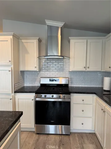 a kitchen with white cabinets and appliances