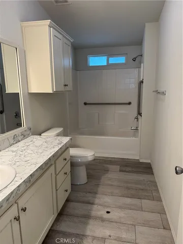 a bathroom with a granite countertop sink a toilet and bathtub