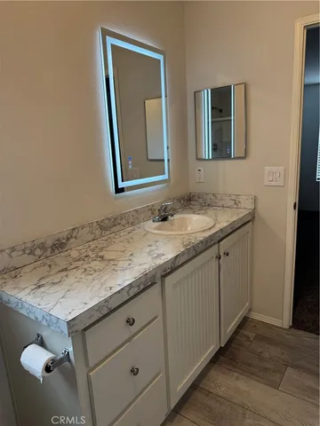 a bathroom with a granite countertop sink and a mirror