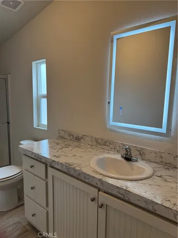 a bathroom with a granite countertop sink and a mirror