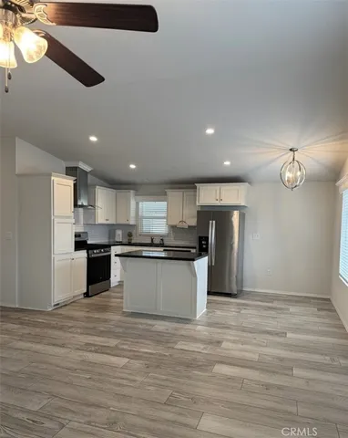 a large kitchen with stainless steel appliances granite countertop a stove and a refrigerator