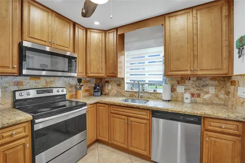 a kitchen with granite countertop stainless steel appliances a stove sink and microwave