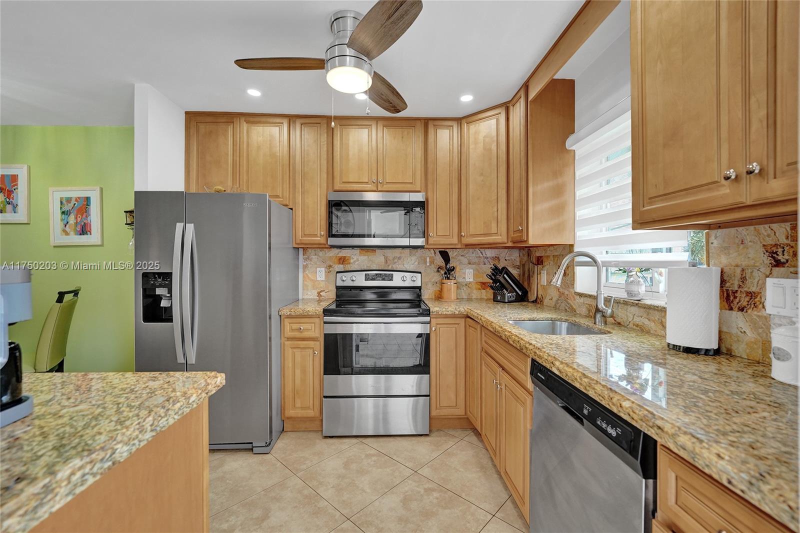 5300 Washington Street, Unit I203 Hollywood, FL 33021 - Photo 17 of 75 a kitchen with granite countertop a stove sink and refrigerator