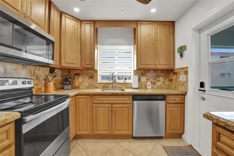 a kitchen with stainless steel appliances granite countertop a refrigerator and a sink
