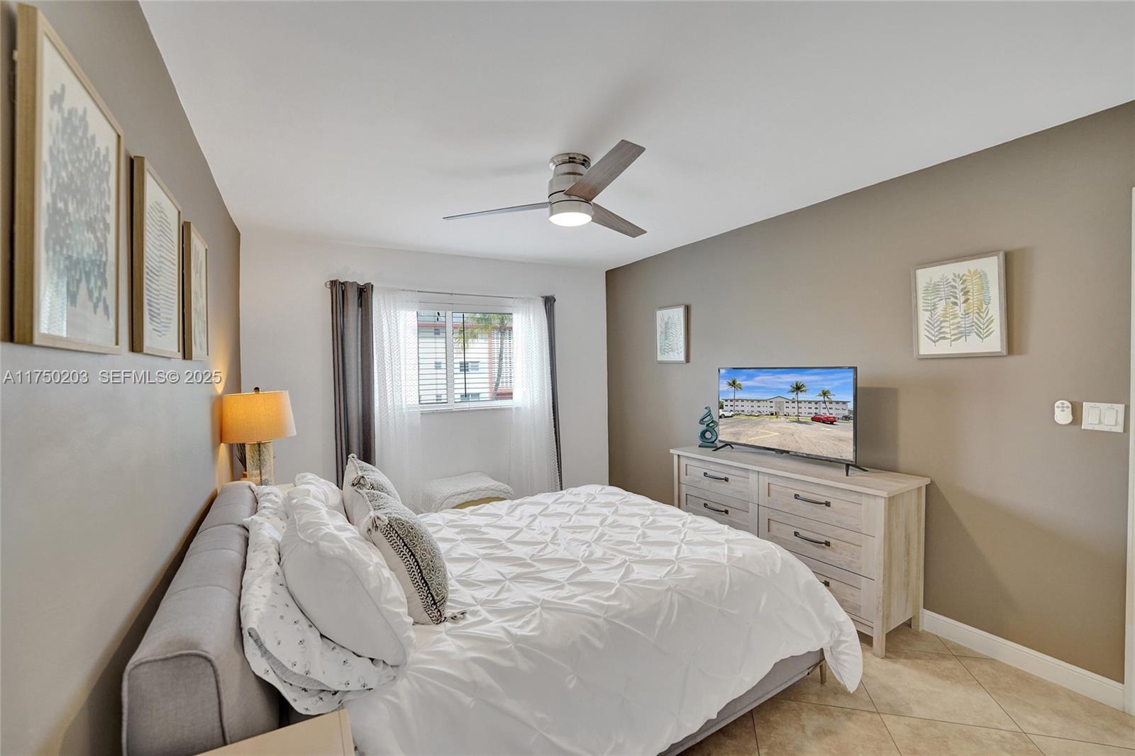 5300 Washington Street, Unit I203 Hollywood, FL 33021 - Photo 30 of 75 a bedroom with a bed and a chandelier