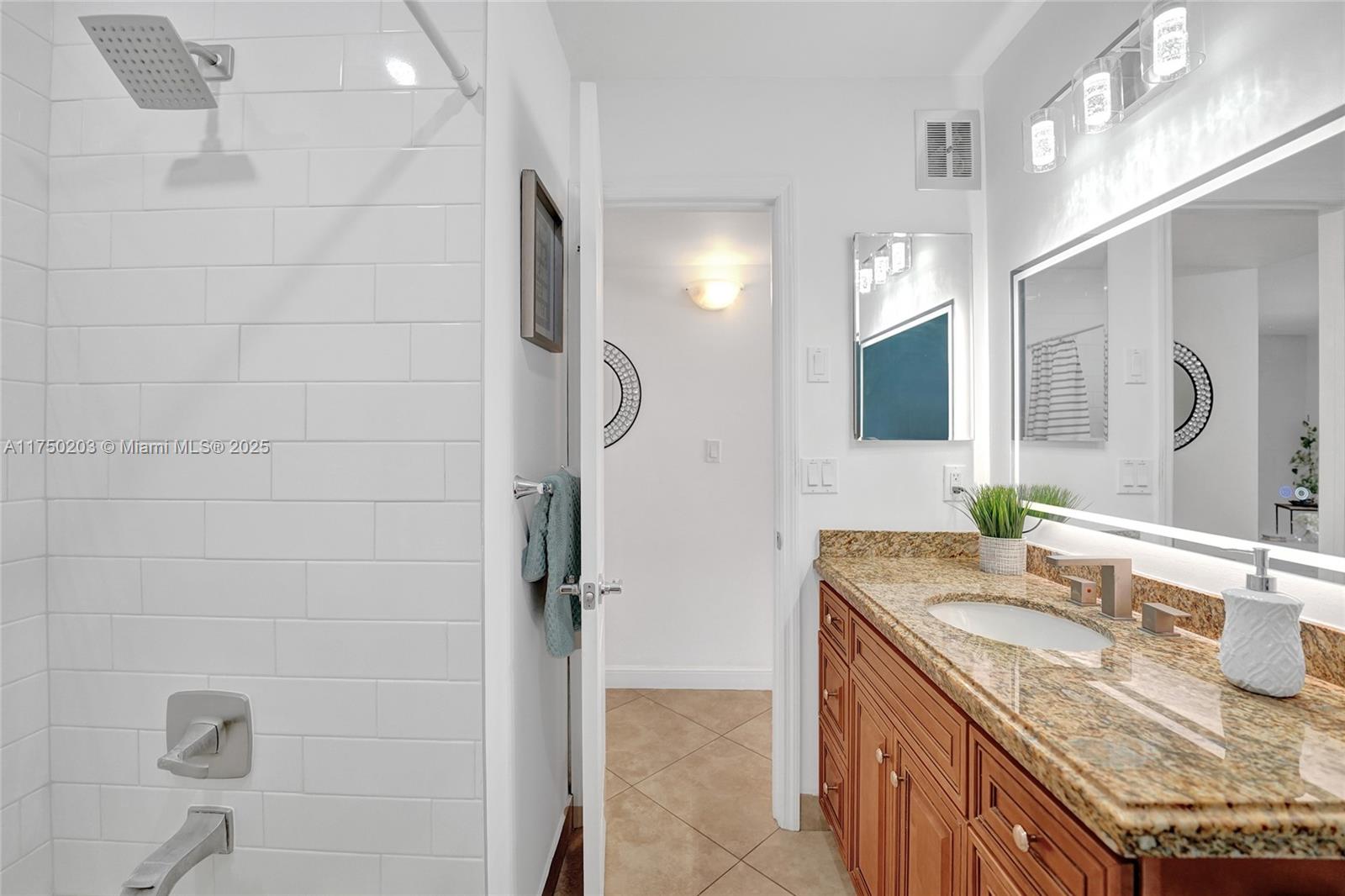 5300 Washington Street, Unit I203 Hollywood, FL 33021 - Photo 39 of 75 a bathroom with a granite countertop sink a mirror and shower
