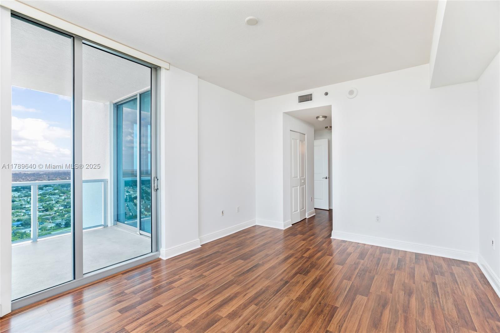 2641 North Flamingo Road, Unit 2608N Sunrise, FL 33323 - Photo 11 of 15 a view of an empty room with wooden floor and a window