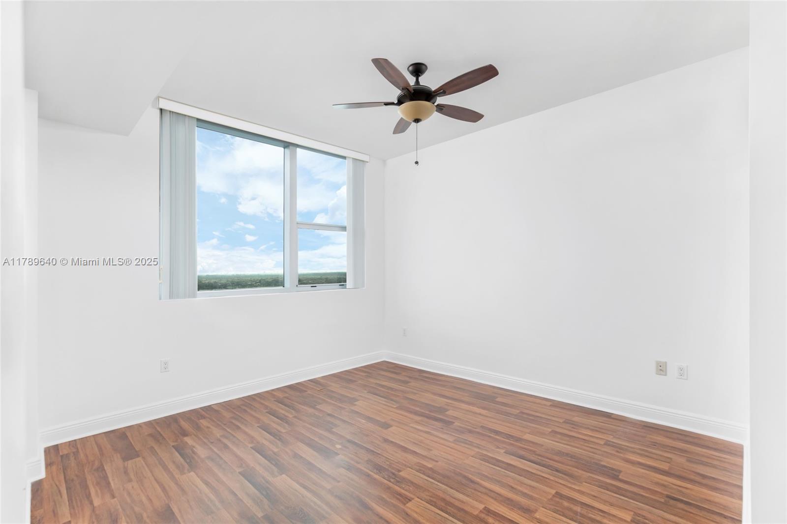 2641 North Flamingo Road, Unit 2608N Sunrise, FL 33323 - Photo 12 of 15 a view of a room with wooden floor and a ceiling fan
