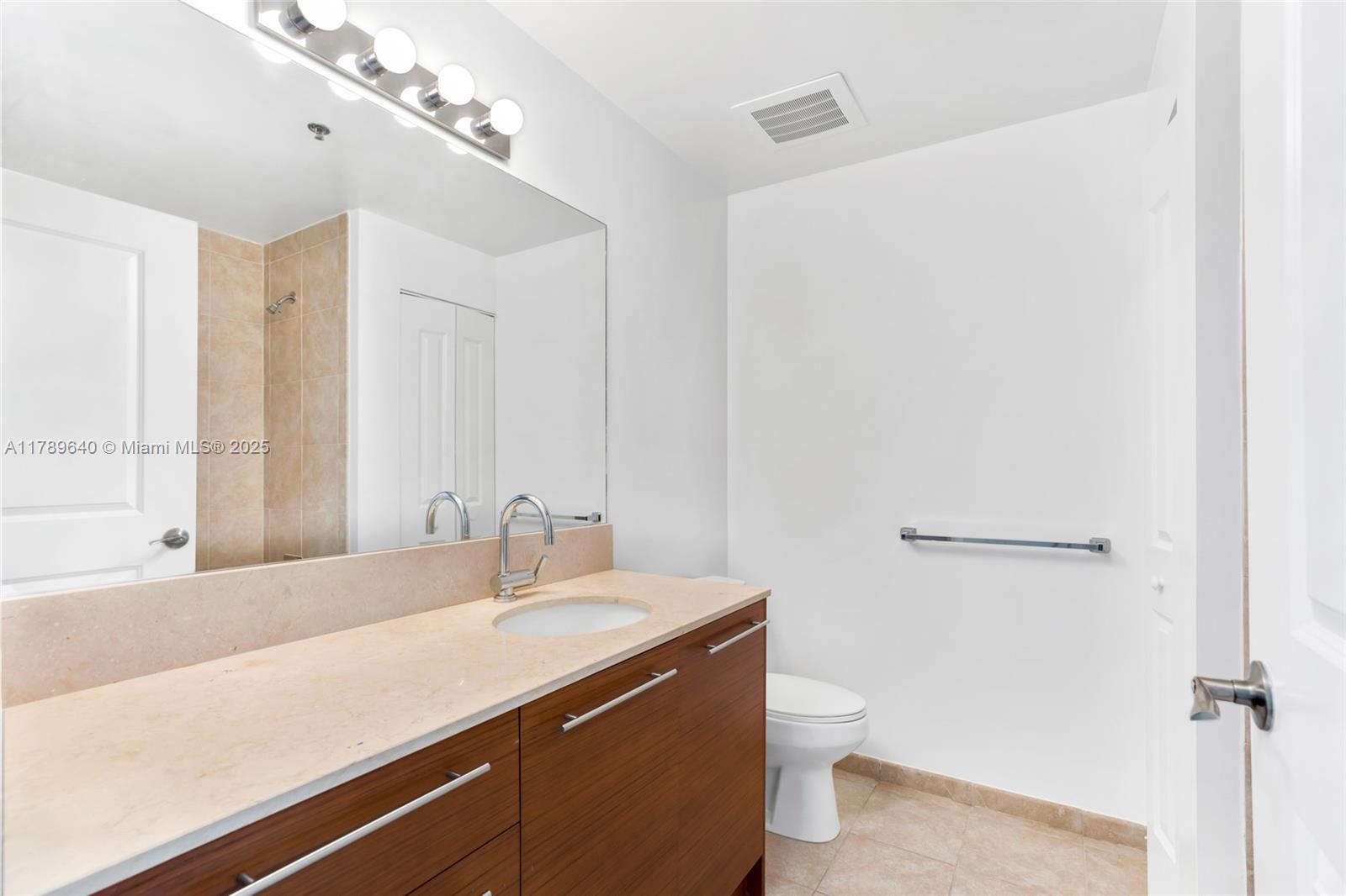 2641 North Flamingo Road, Unit 2608N Sunrise, FL 33323 - Photo 5 of 15 a bathroom with a granite countertop sink a toilet and a mirror