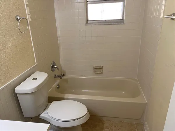 a white toilet and tub sitting next to a bathroom sink