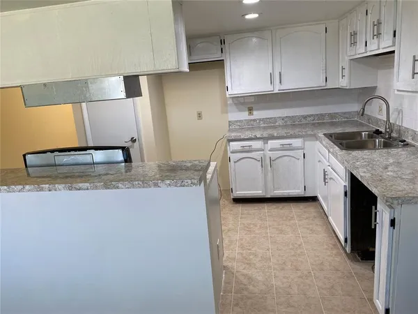 a kitchen with granite countertop a sink stove and cabinets