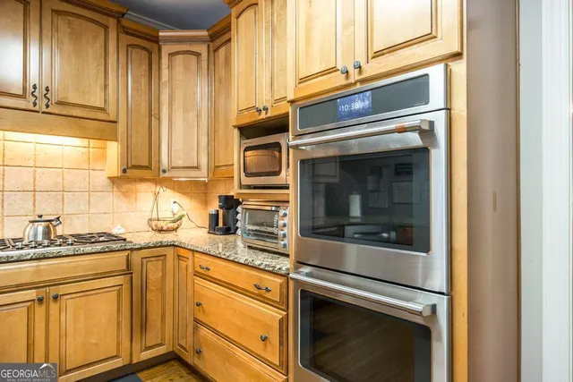 a kitchen with granite countertop cabinets stainless steel appliances and a sink