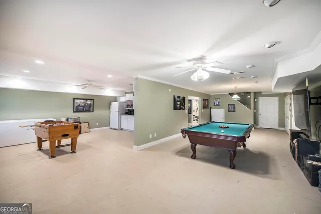 a kitchen with stainless steel appliances a white stove top oven a sink a dining table and chairs