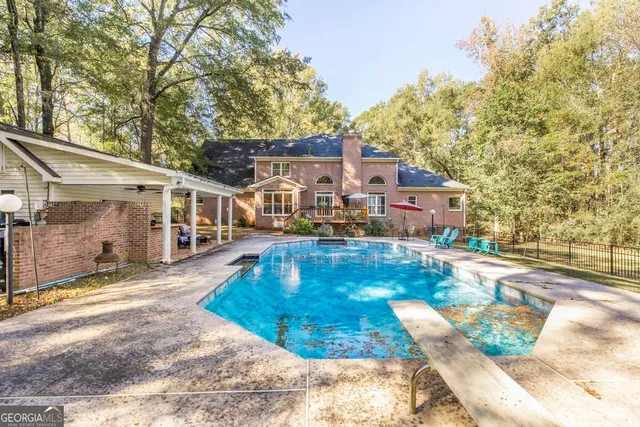 a view of a white house with a yard and sitting area