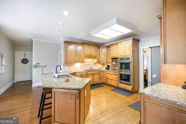 a kitchen with stainless steel appliances granite countertop sink refrigerator and stove