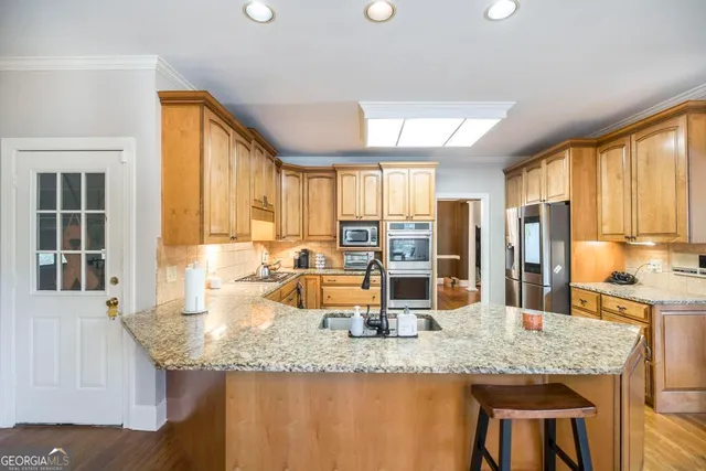 a kitchen with granite countertop sink and wooden cabinets