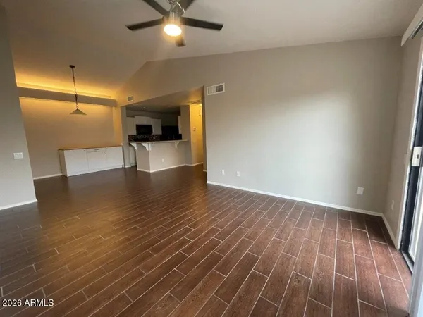 an empty room with wooden floor and windows