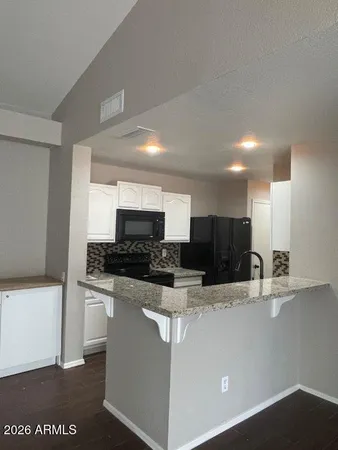 a kitchen with stainless steel appliances a sink a stove a microwave a refrigerator a counter top and oven