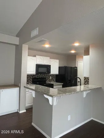 a kitchen with stainless steel appliances a sink a stove a microwave a refrigerator a counter top and oven