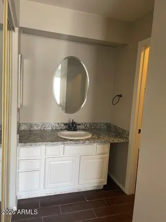 a bathroom with a granite countertop sink a mirror and shower