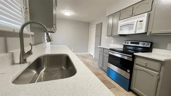 a kitchen with sink a microwave and stove