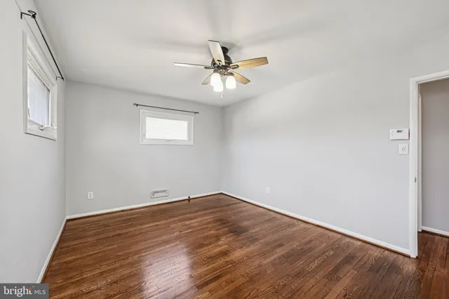 a view of a room with wooden floor and a ceiling fan
