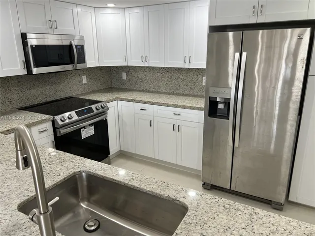 a kitchen with a stove sink and refrigerator