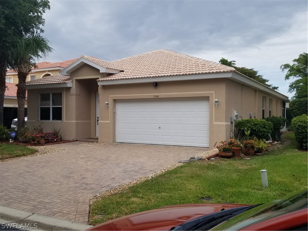 9341 Chestnut Tree Loop Fort Myers, FL 33967 - Photo 7 of 31 a front view of a house with a garden and yard