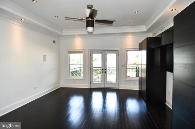 an empty room with wooden floor and windows