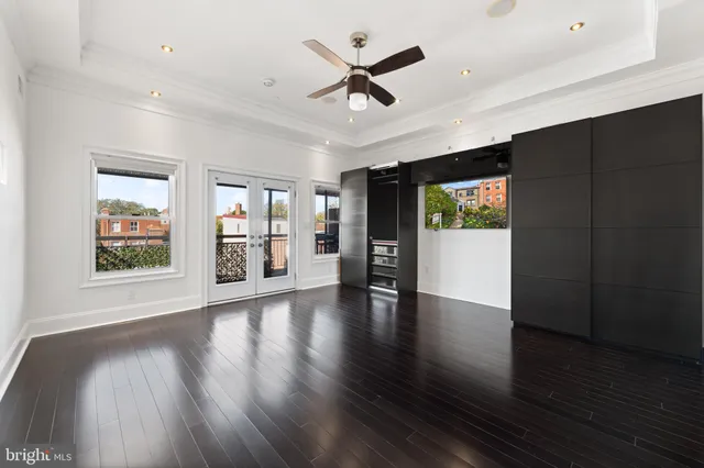 a view of an empty room with a window and wooden floor