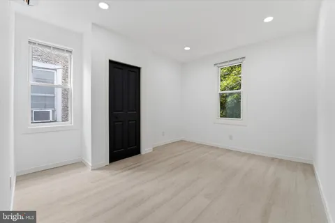an empty room with windows and closet