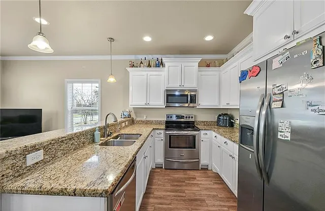 a kitchen with stainless steel appliances granite countertop a sink stove and refrigerator
