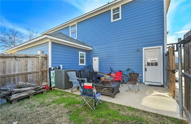 a view of backyard with seating space and wooden fence