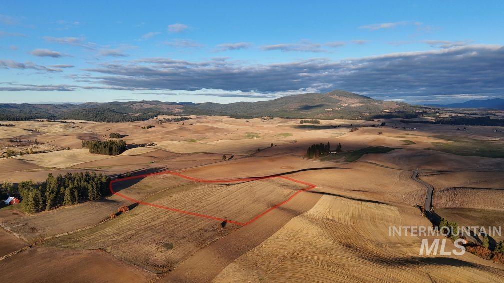 Overview of rural landscape with a mountainous background and property parcel outlined