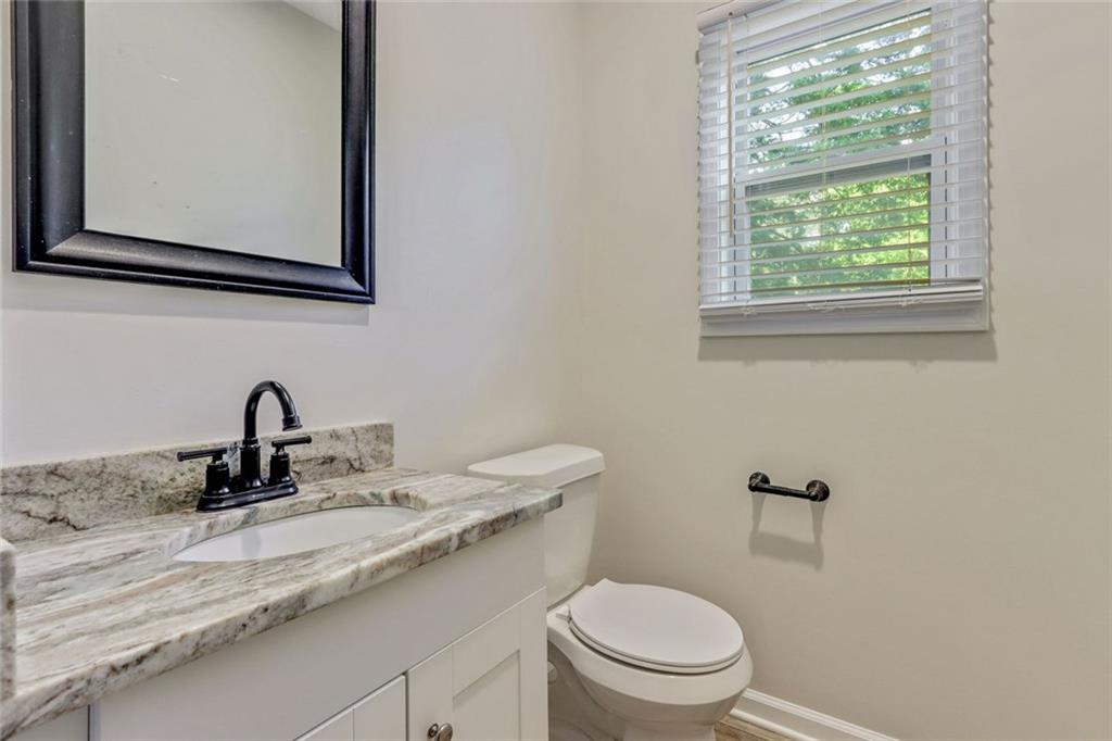 129 Pierce Hill Road Northeast Rome, GA 30161 - Photo 11 of 25 a bathroom with a granite countertop sink toilet and a window