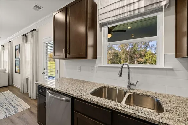 a kitchen with granite countertop a sink and cabinets