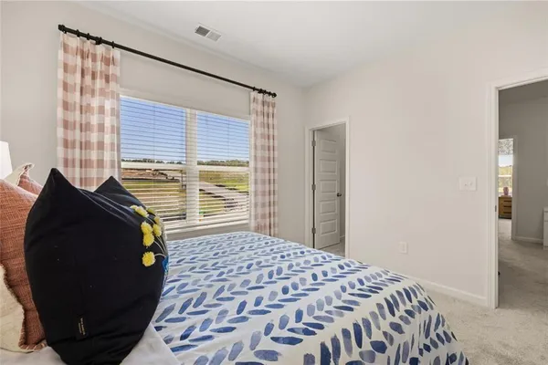 a bedroom with bed and paintings on the wall