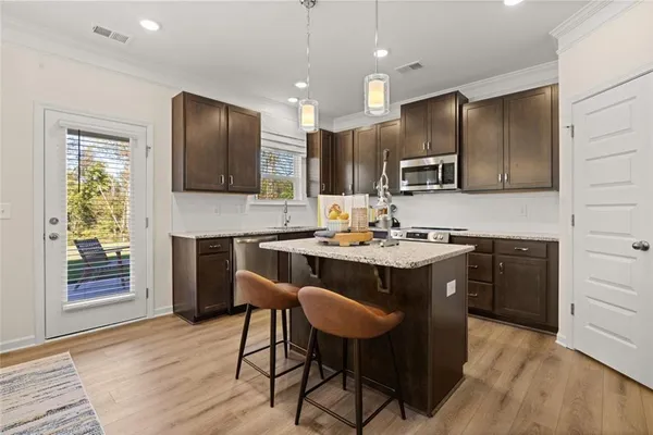 a kitchen with a sink cabinets and wooden floor